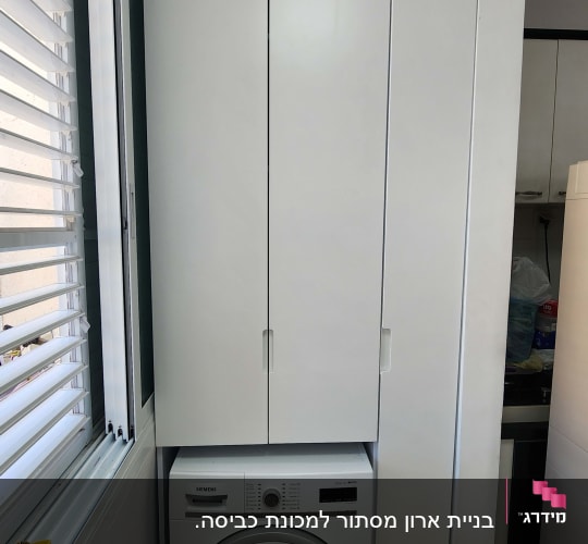 ארון לבן עם מכונת כביסה מתחת